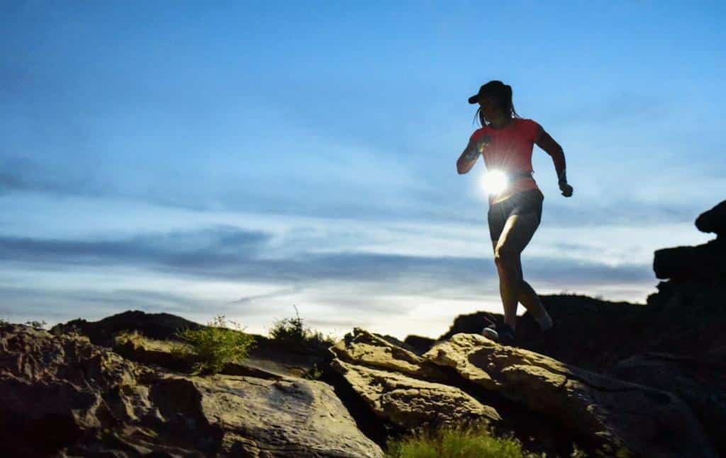 A person running on a rocky trail in the dark