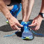 Picture of a runner tying his shoes