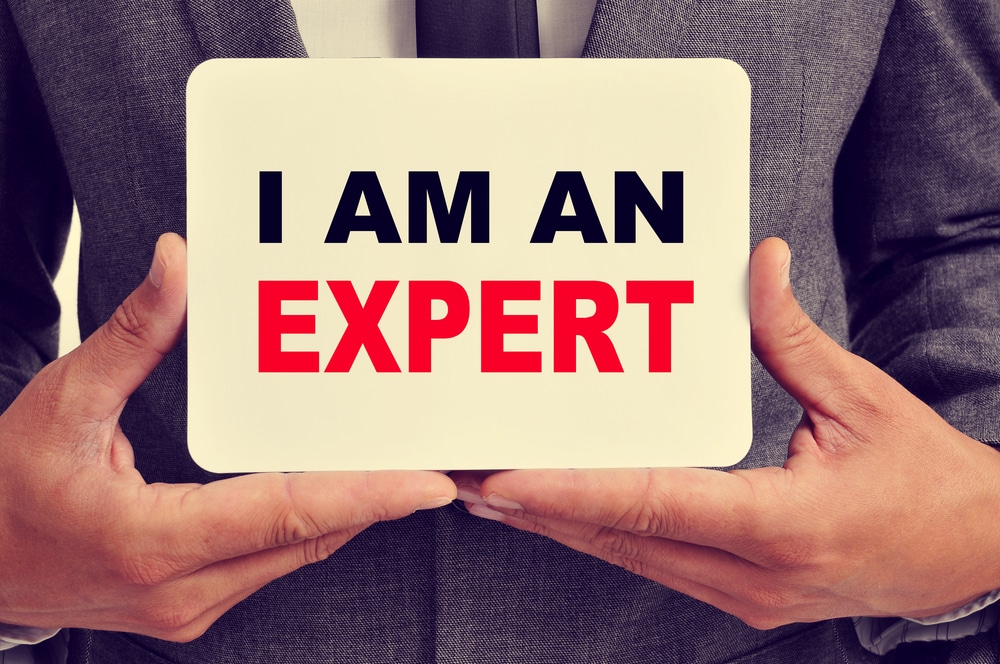 Man holding a sign that says I am An Expert