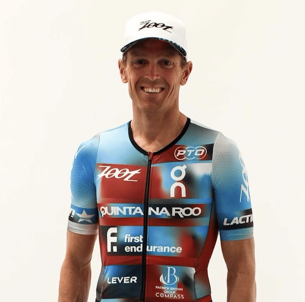 matt smiling with a white hat and running shirt with many logos