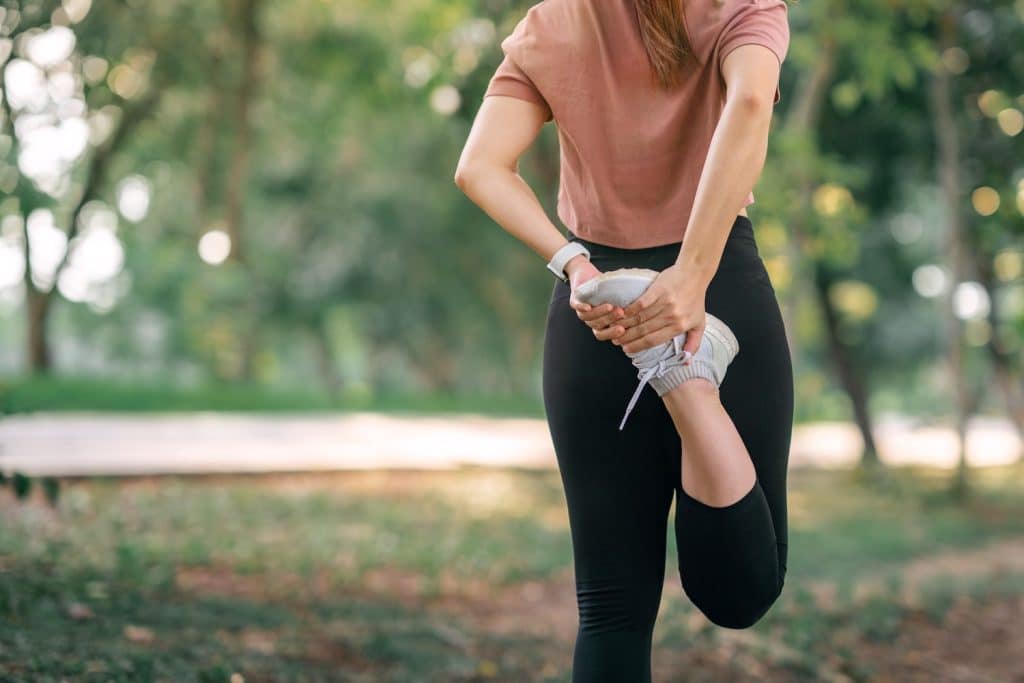 Close up - Runner woman stretching legs before running in the park