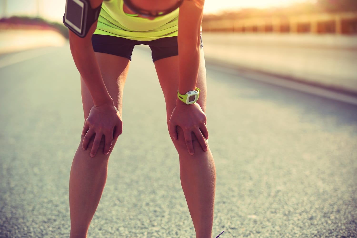 tired woman runner taking a rest after running hard on city road