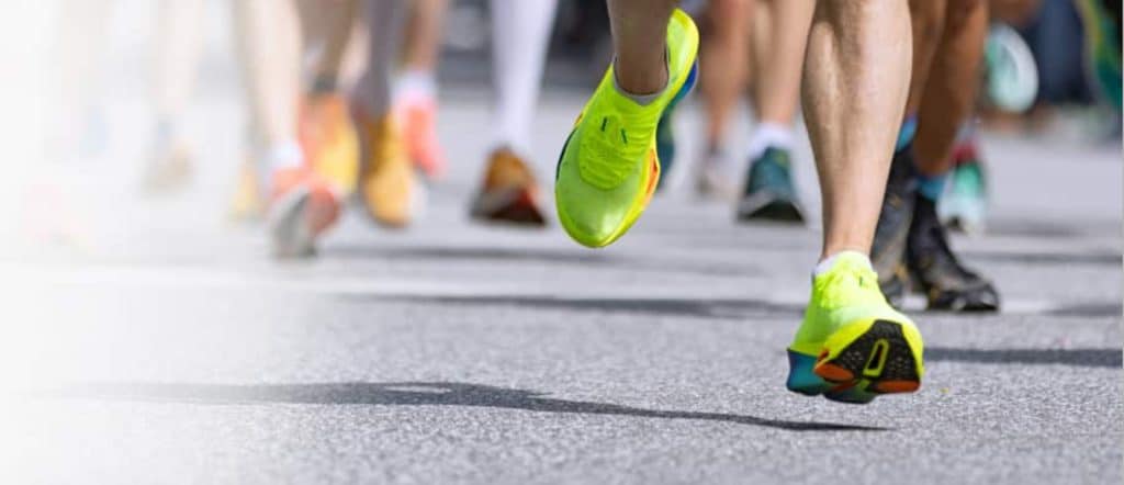 people running on a hard surface with just legs and feet showing