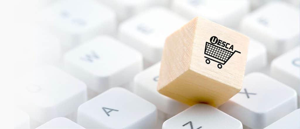 keyboard with a wooden block with a shopping cart and the UESCA logo