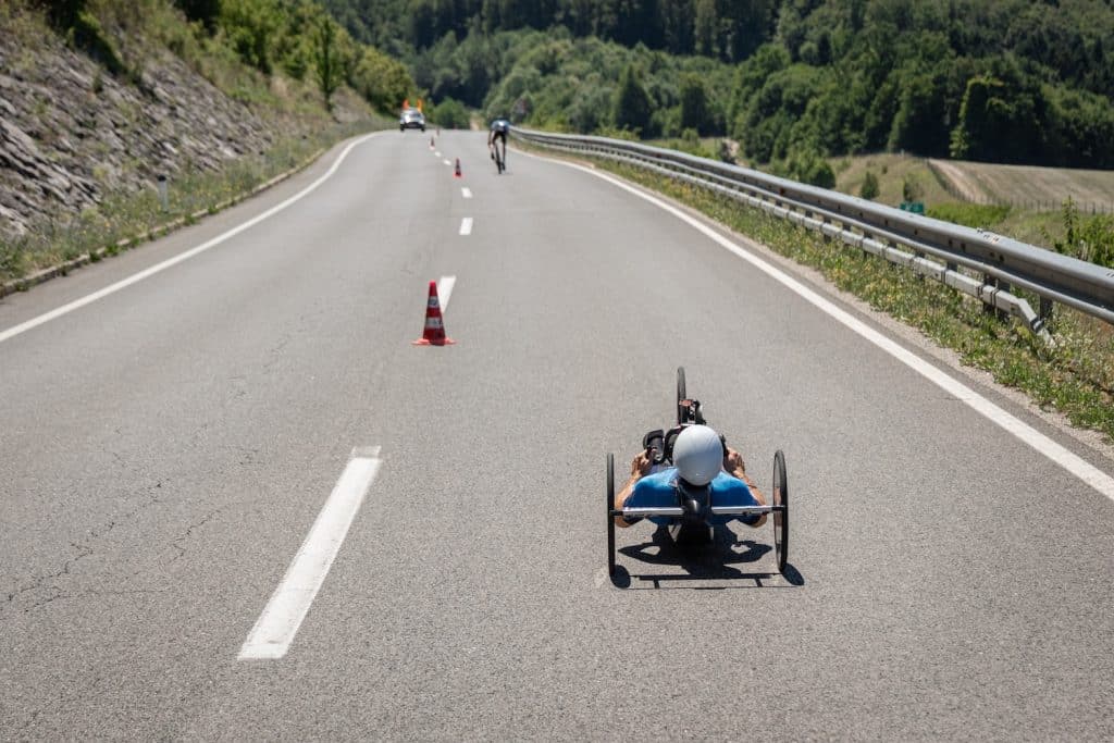 Paracyclist racing on a handcycle during a road cycling competition on a closed mountain road