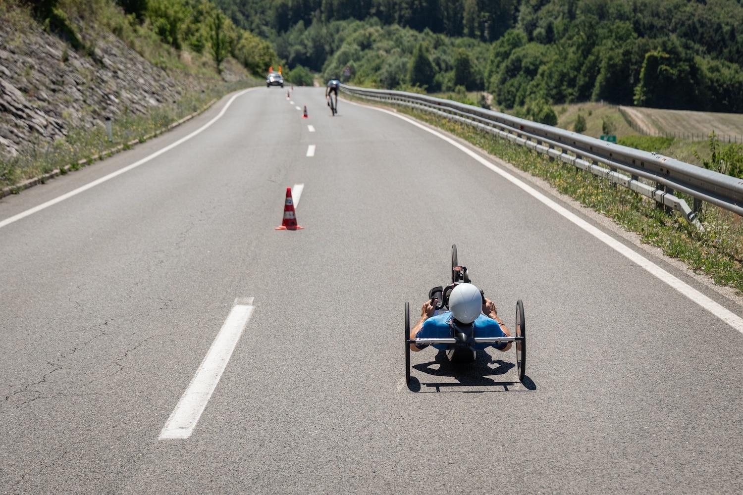 Paracyclist racing on a handcycle during a road cycling competition on a closed mountain road